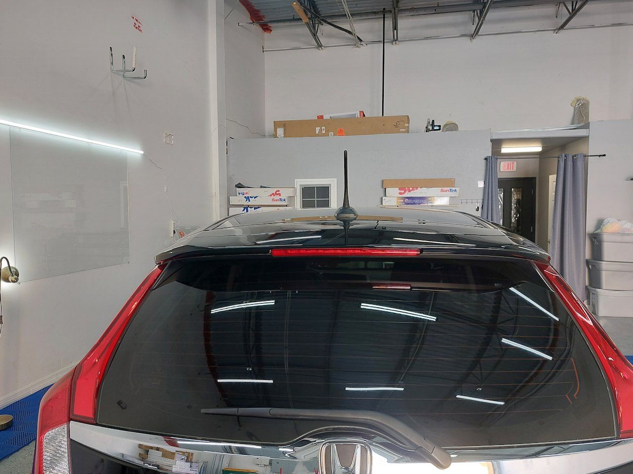 A red and black car is parked in a garage.