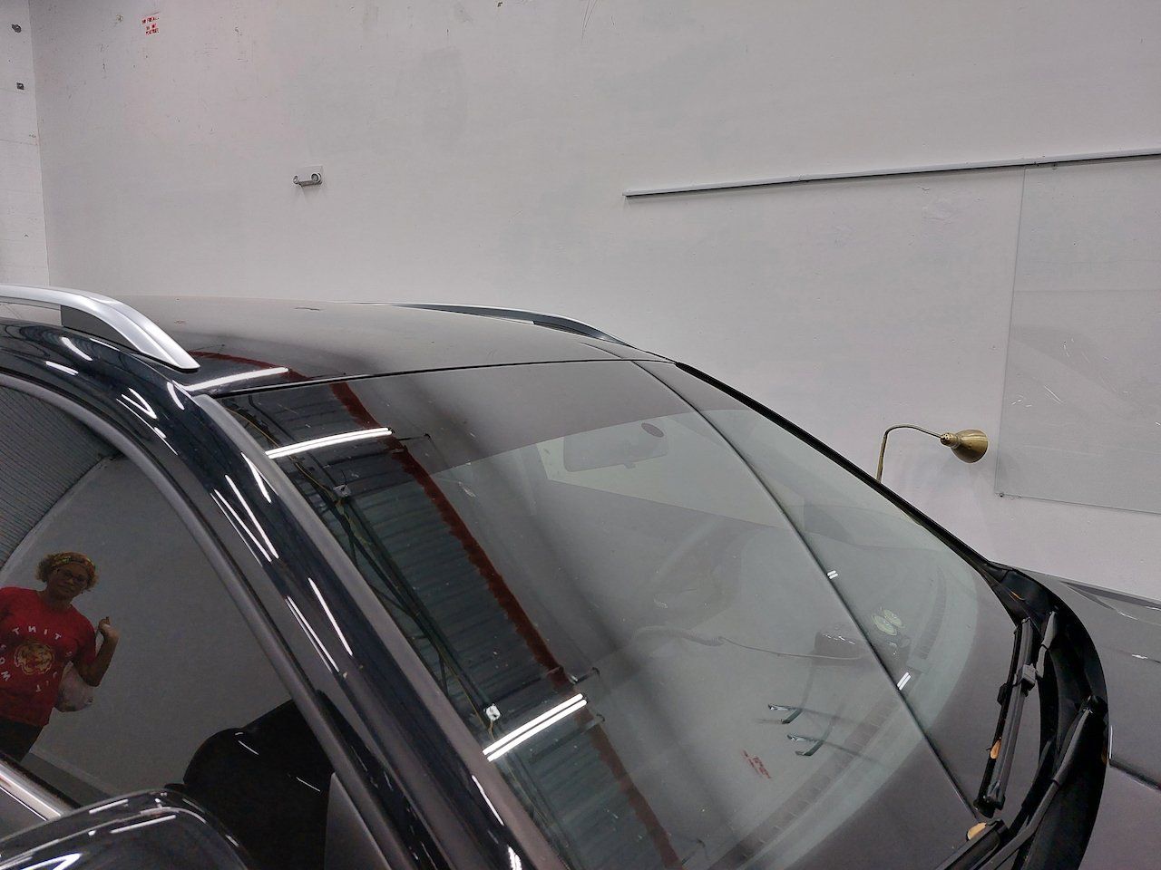 A car with a broken windshield is parked in a garage.