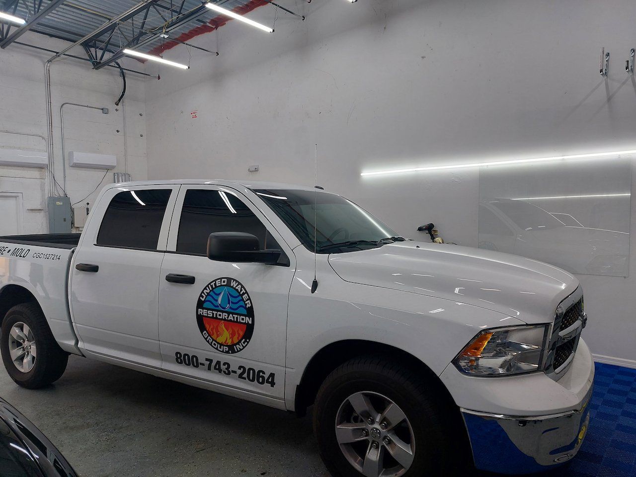 A white dodge ram truck is parked in a garage.