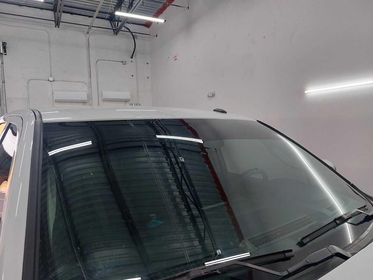 A close up of a car windshield in a garage.