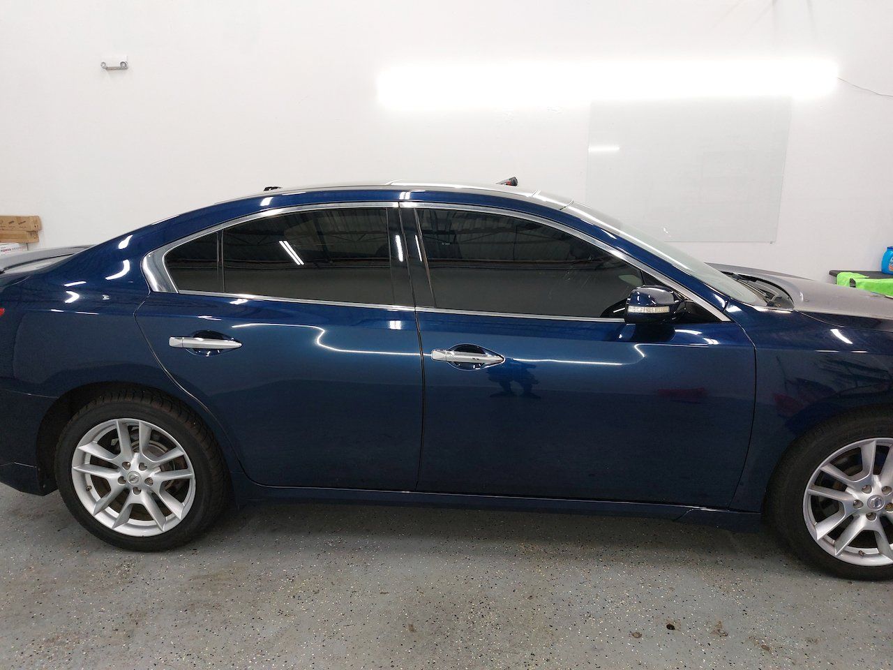 A blue car is parked in a garage.