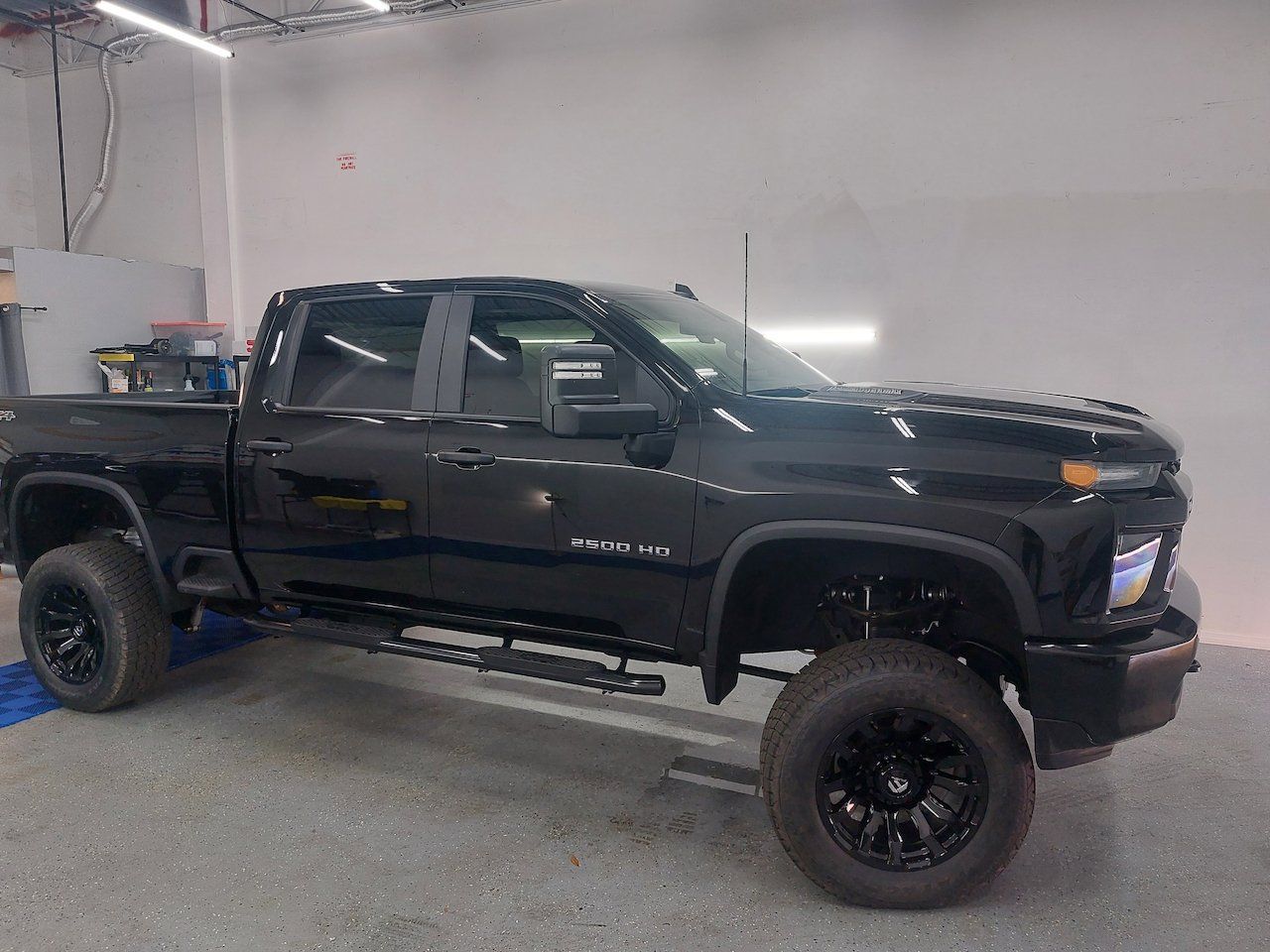 A black pickup truck is parked in a garage.