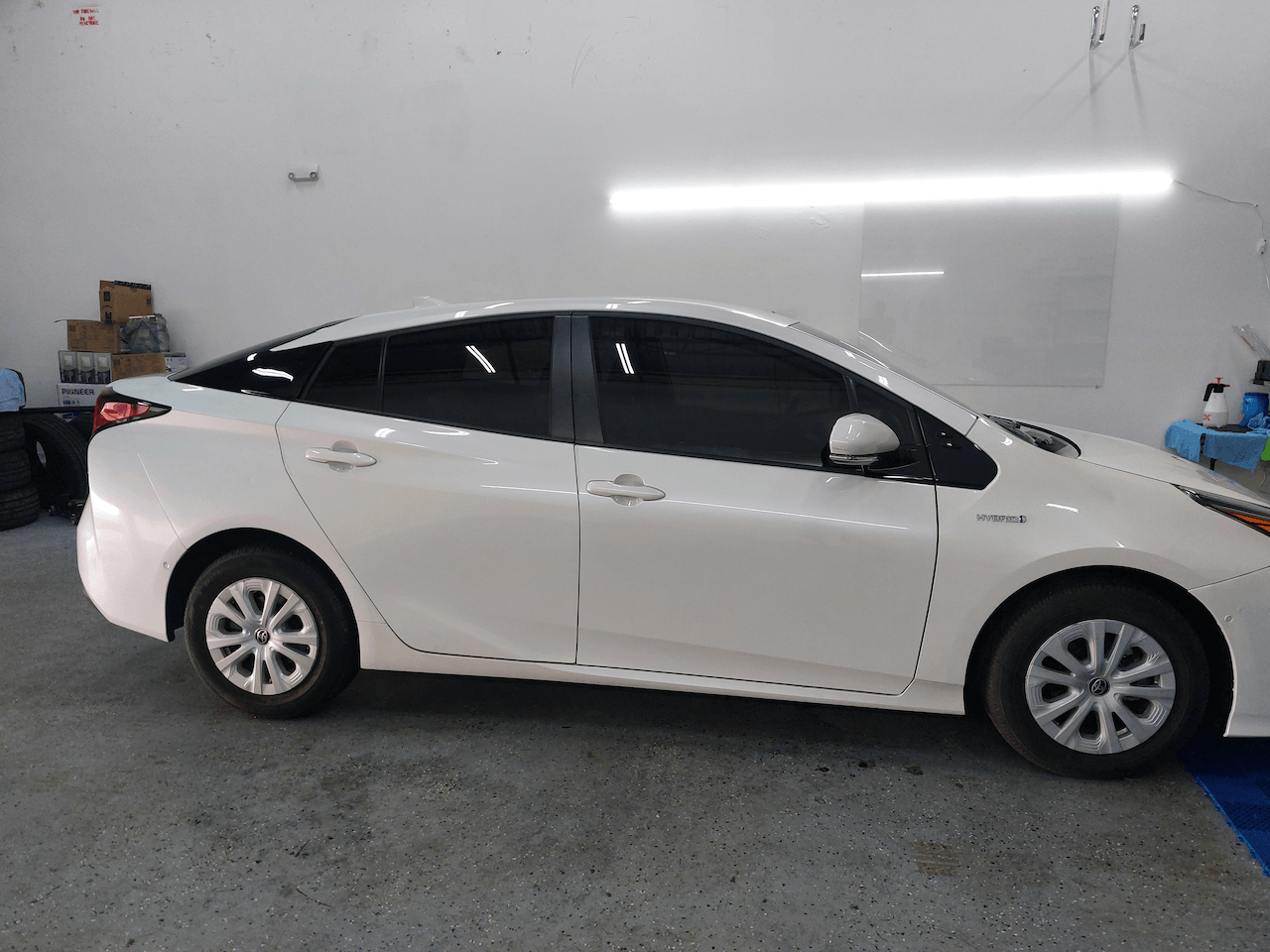 A white toyota prius is parked in a garage.