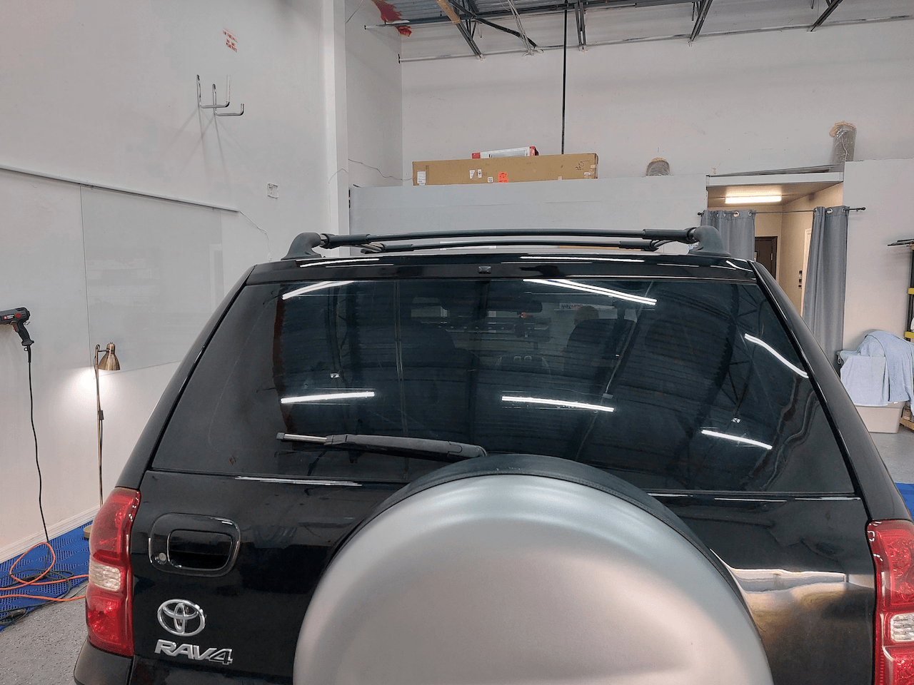 A black toyota rav4 is parked in a garage