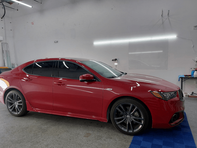 A red car is parked in a garage.