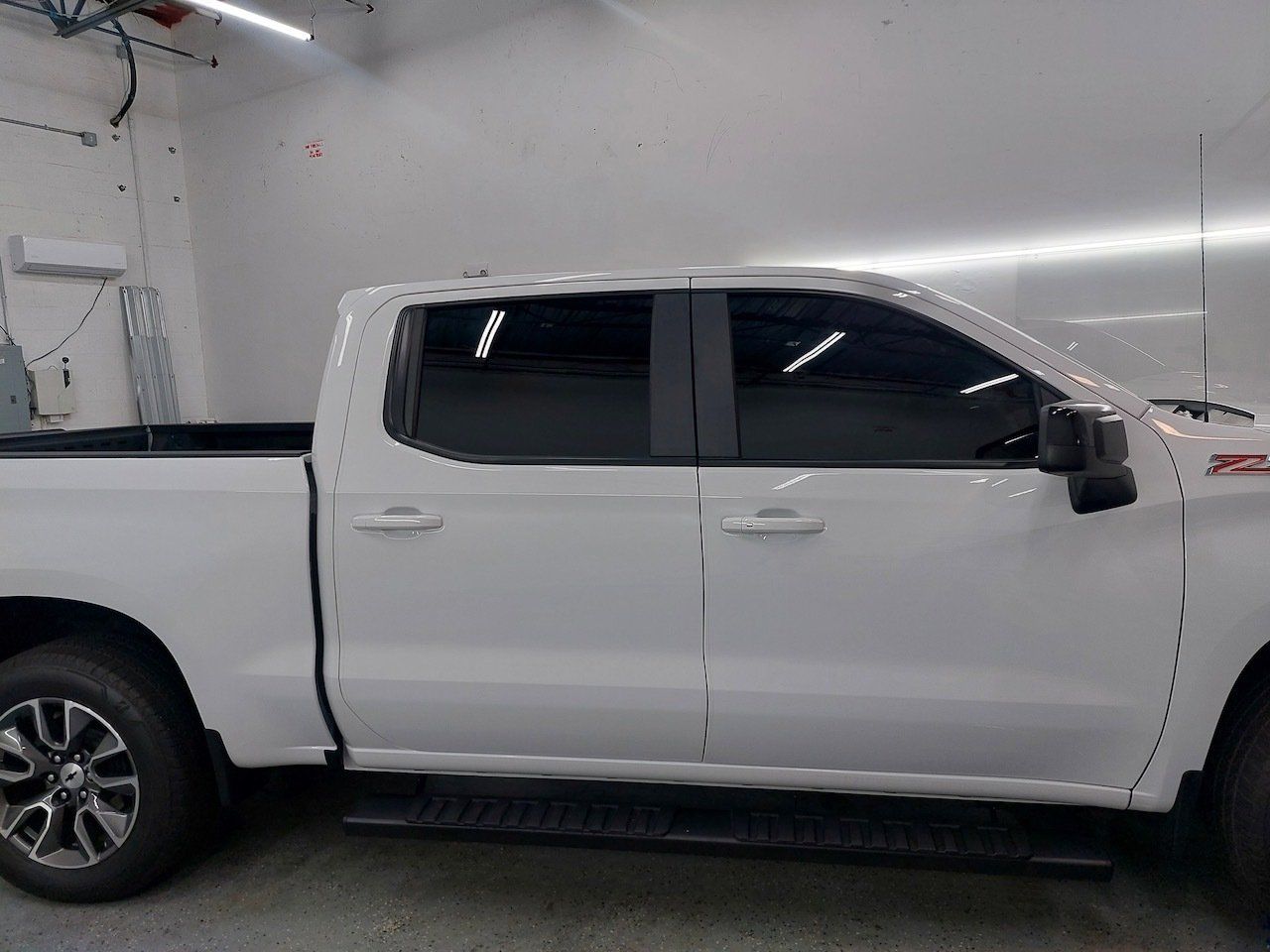 A white pickup truck is parked in a garage.
