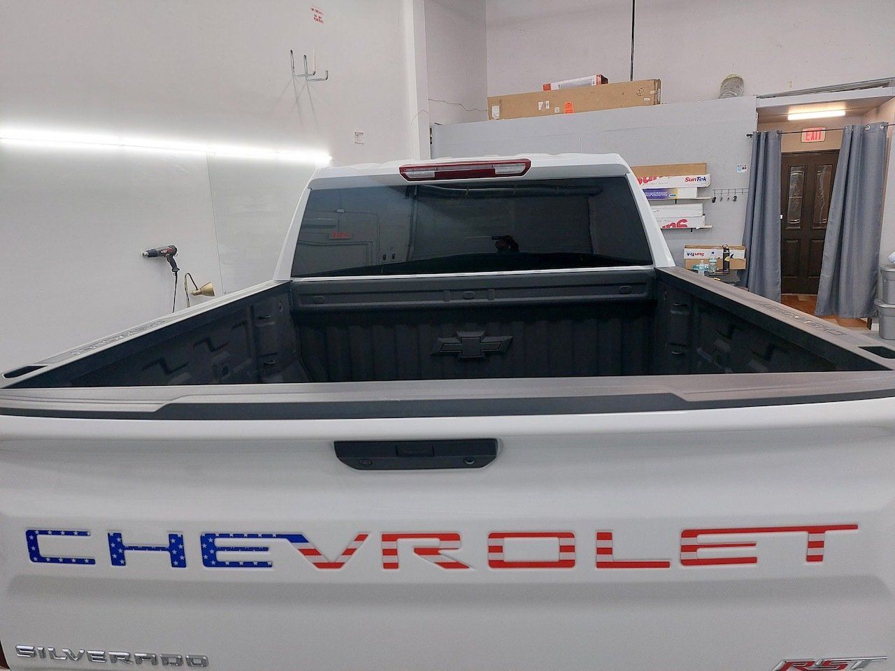 A white chevrolet truck is parked in a garage.