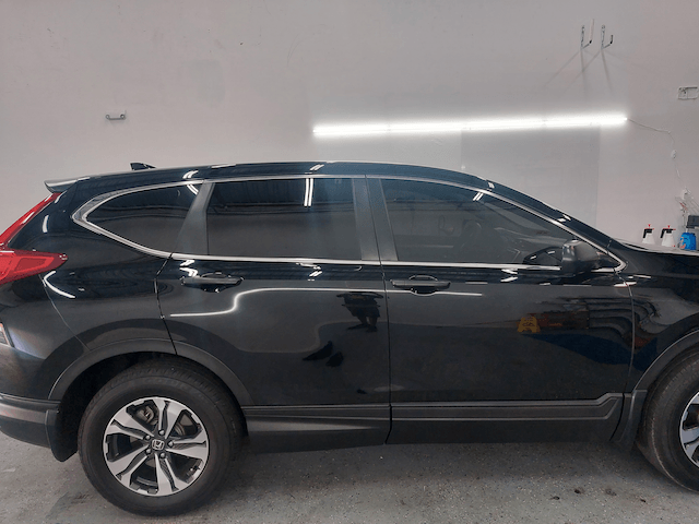 A black honda cr v is parked in a garage