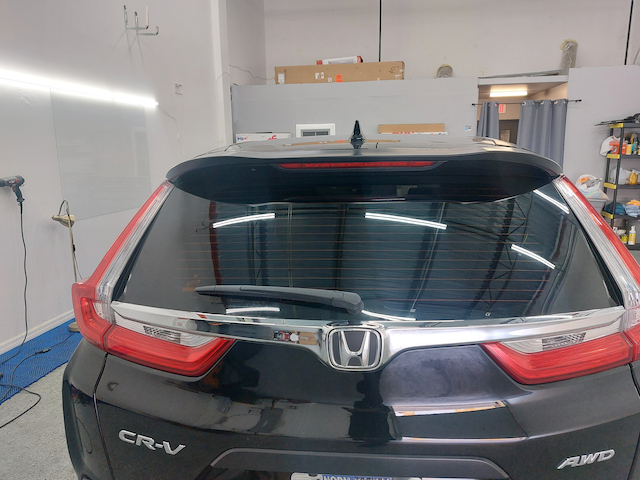 A black honda crv is parked in a garage