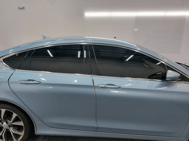 A light blue car is parked in a garage.