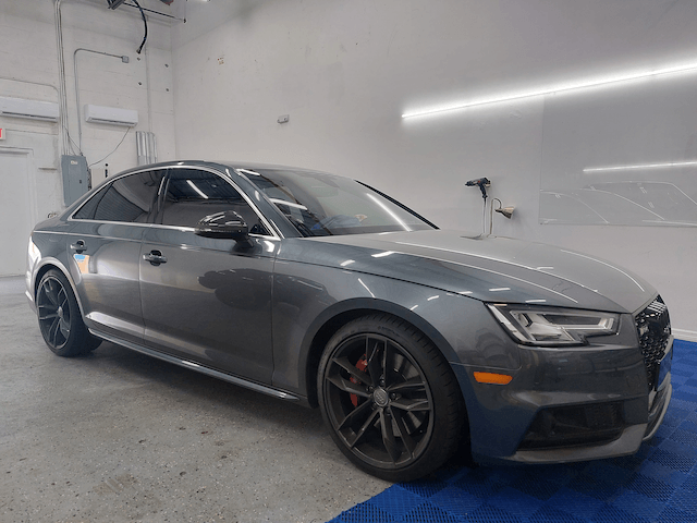 A gray audi a4 is parked in a garage.