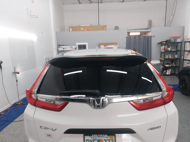 A white honda cr-v is parked in a garage