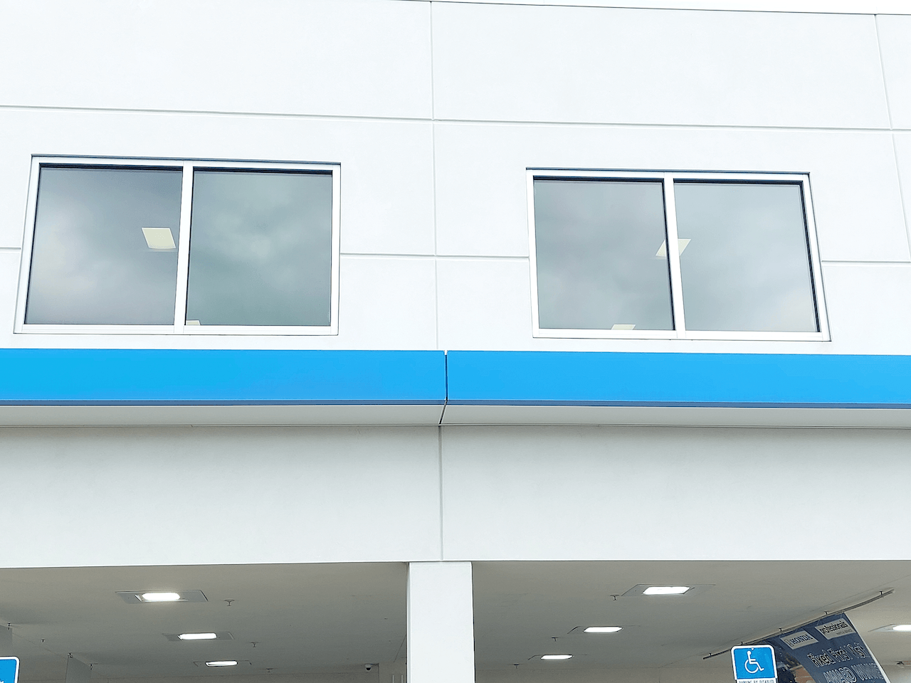 A white building with blue trim and a lot of windows.