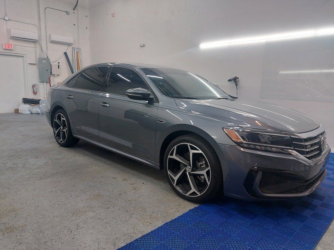 A gray volkswagen passat is parked in a garage.