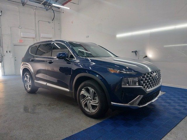 A blue hyundai santa fe is parked in a garage.