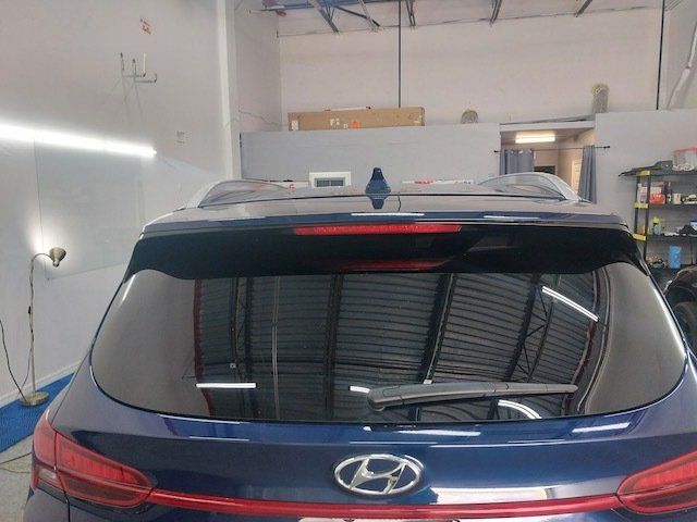 A blue hyundai car is parked in a garage