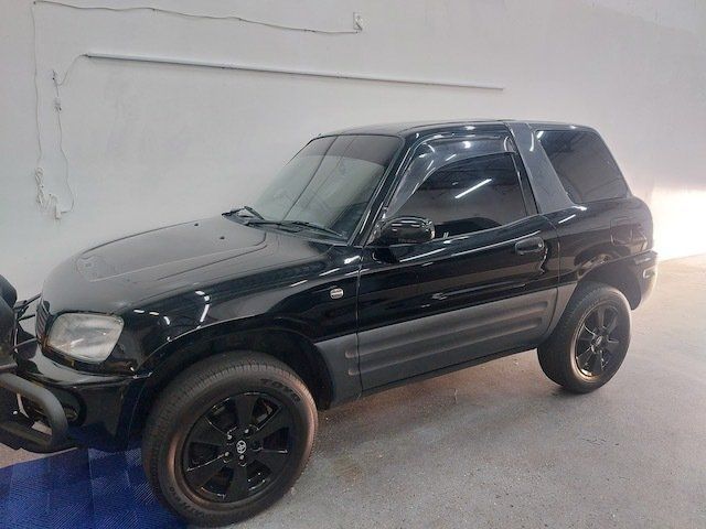 A black toyota rav4 is parked in a garage