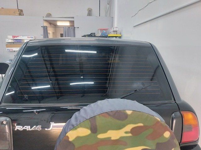 A black rav4 is parked in a garage