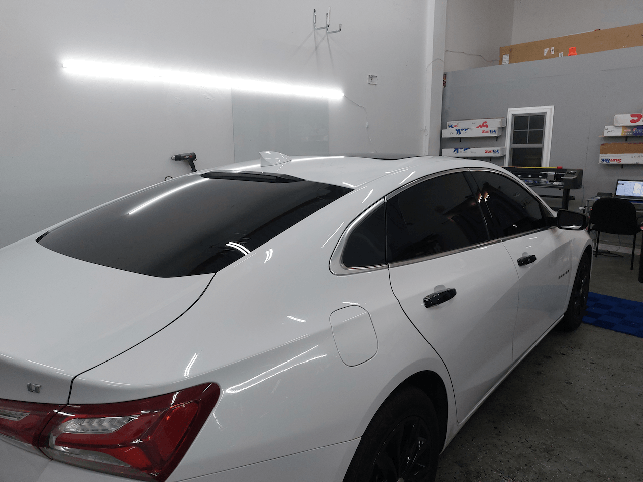 A white car is parked in a garage.