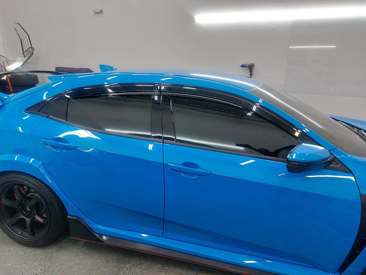 A blue car is parked in a garage.