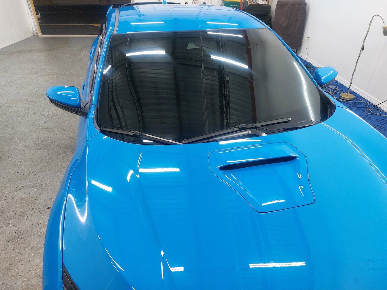 A blue sports car is parked in a garage.