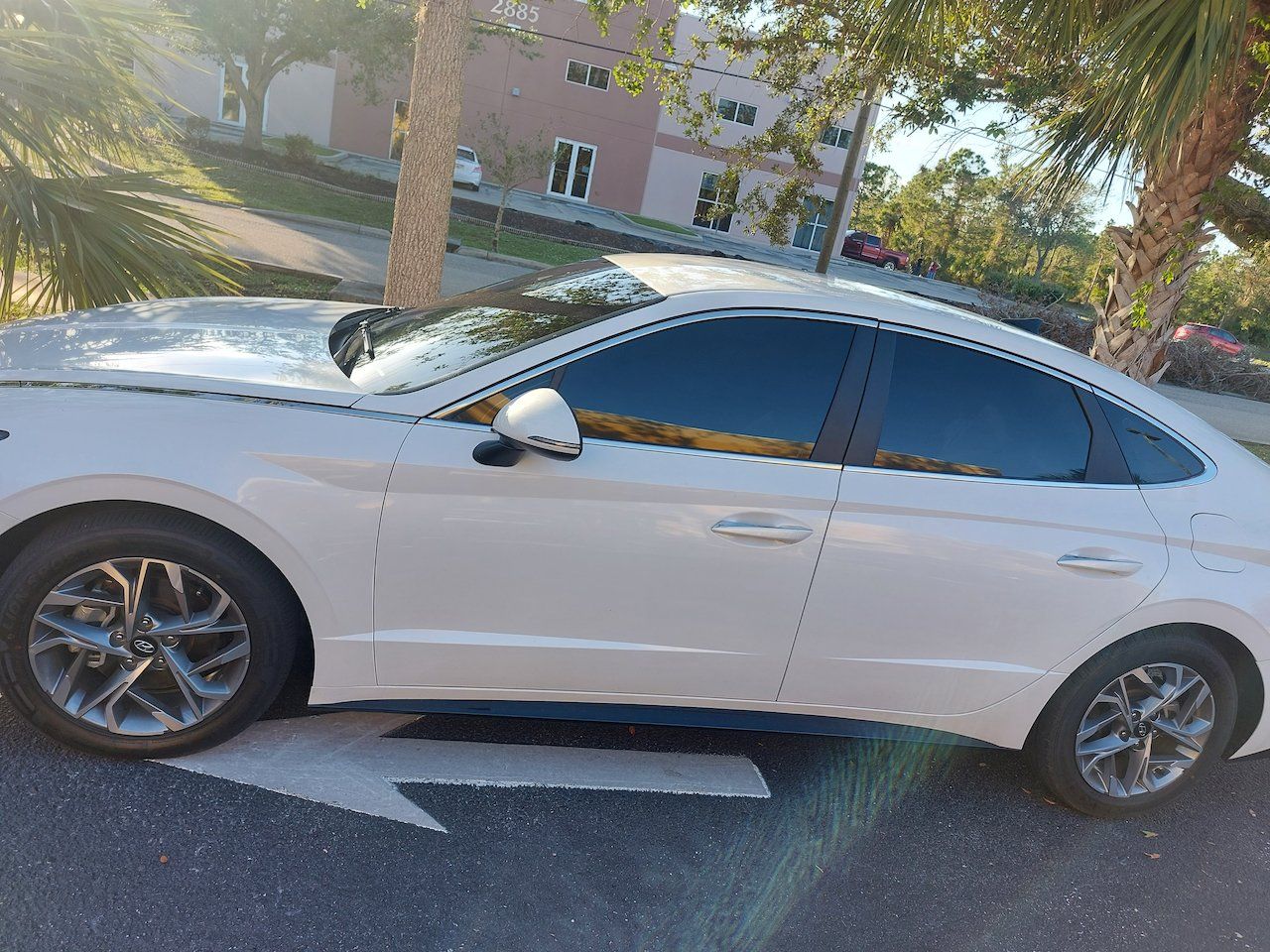 A white car is parked on the side of the road.