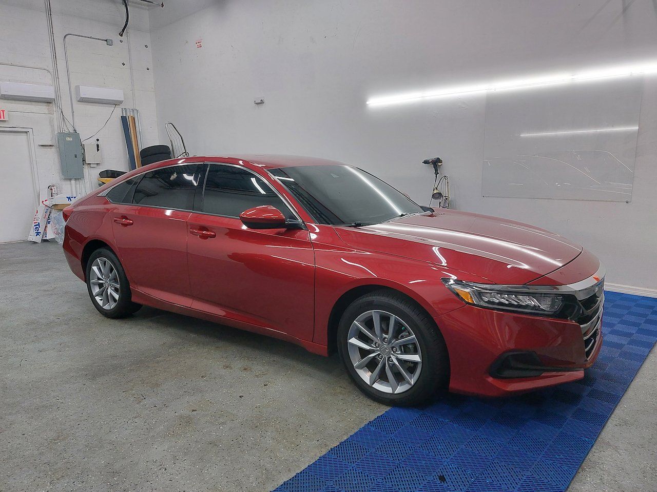 A red honda accord is parked in a garage.