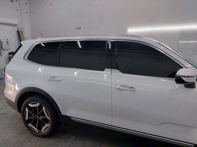 A white suv with black windows is parked in a garage