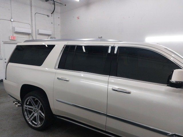 A white suv with black windows is parked in a garage.