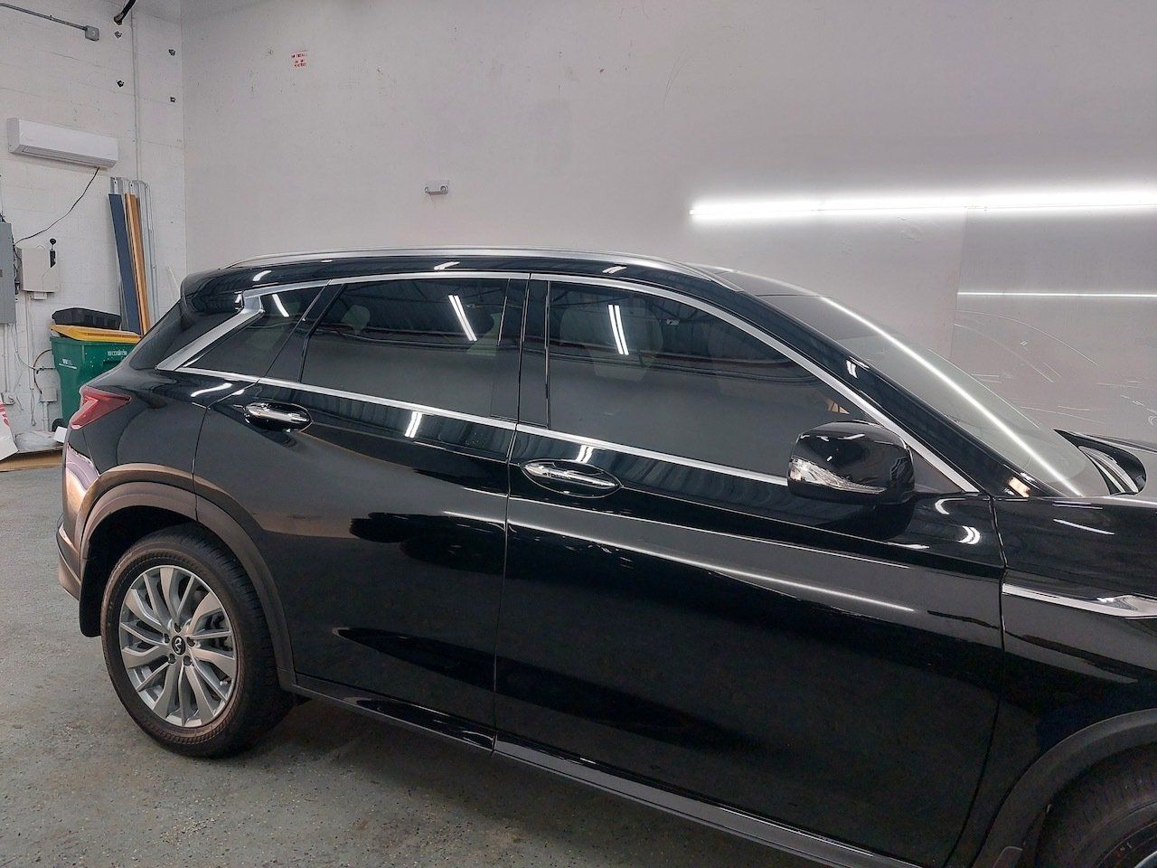 A black car is parked in a garage.