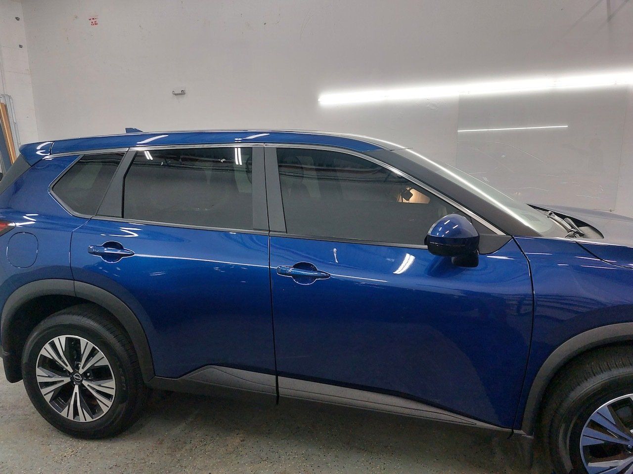 A blue nissan pathfinder is parked in a garage.