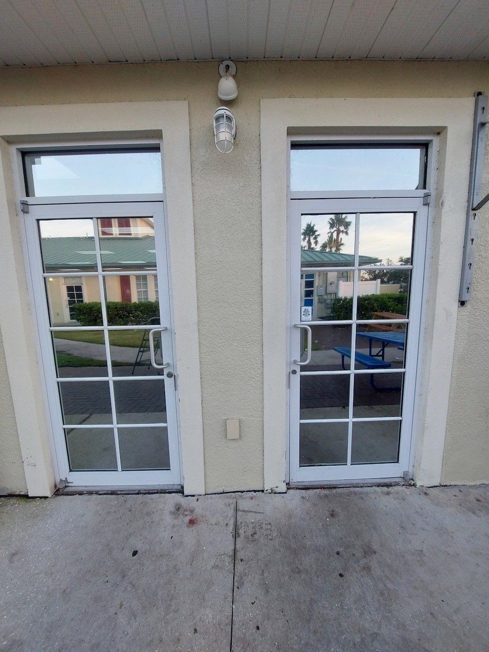 A white door with a reflection of a house in it