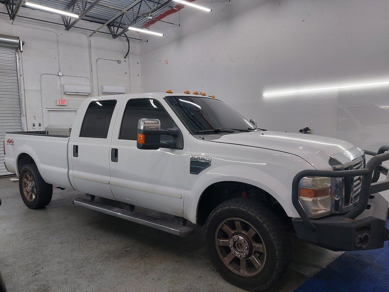 A white pickup truck is parked in a garage.