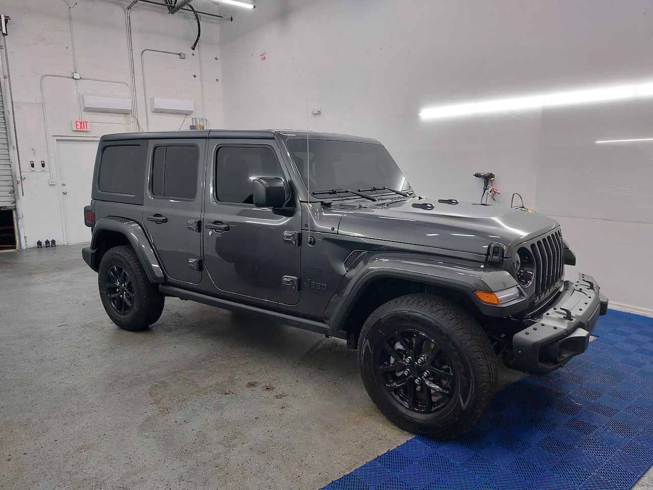 A jeep wrangler is parked in a garage.