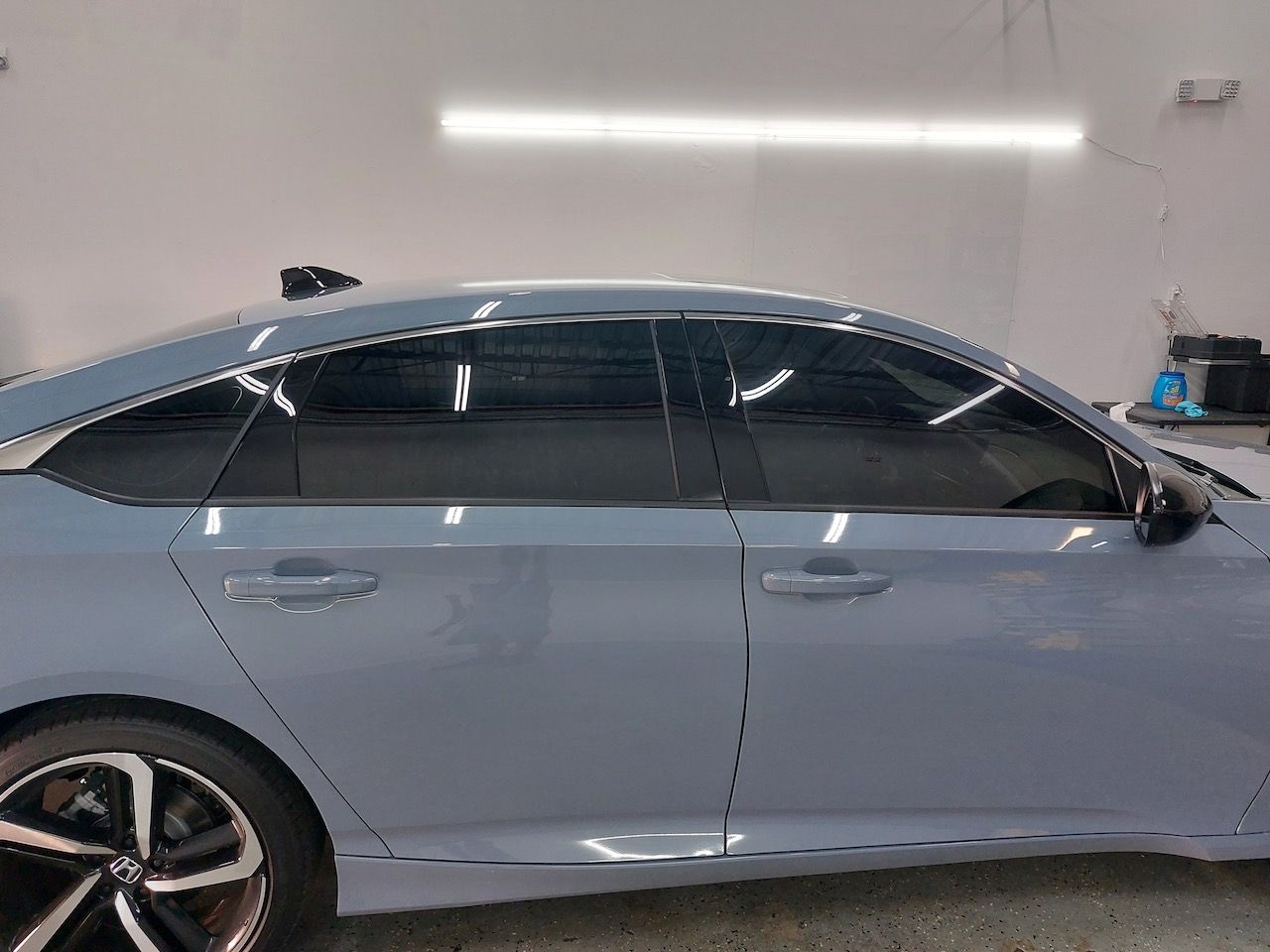 A blue honda accord is parked in a garage.