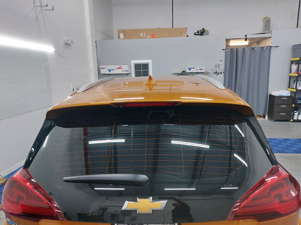 A yellow chevrolet car is parked in a garage.