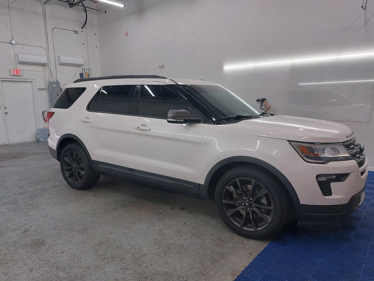 A white ford explorer is parked in a garage.