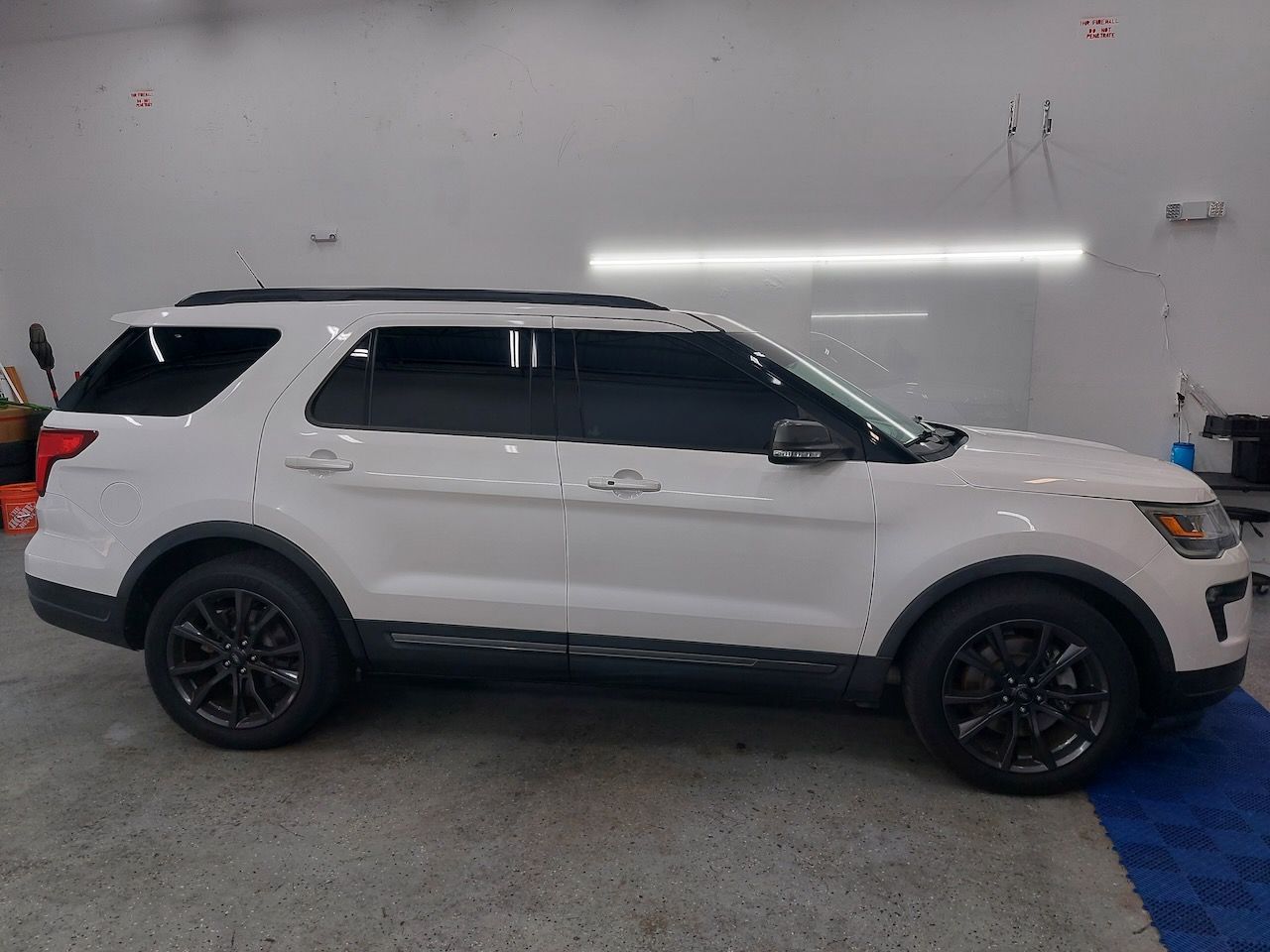 A white ford explorer is parked in a garage.