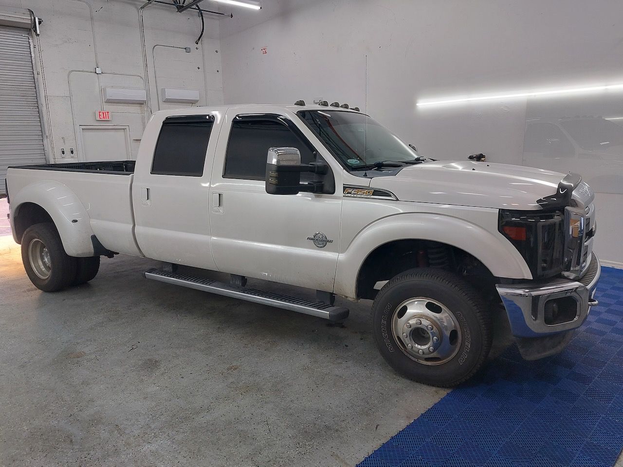 A white pickup truck is parked in a garage.