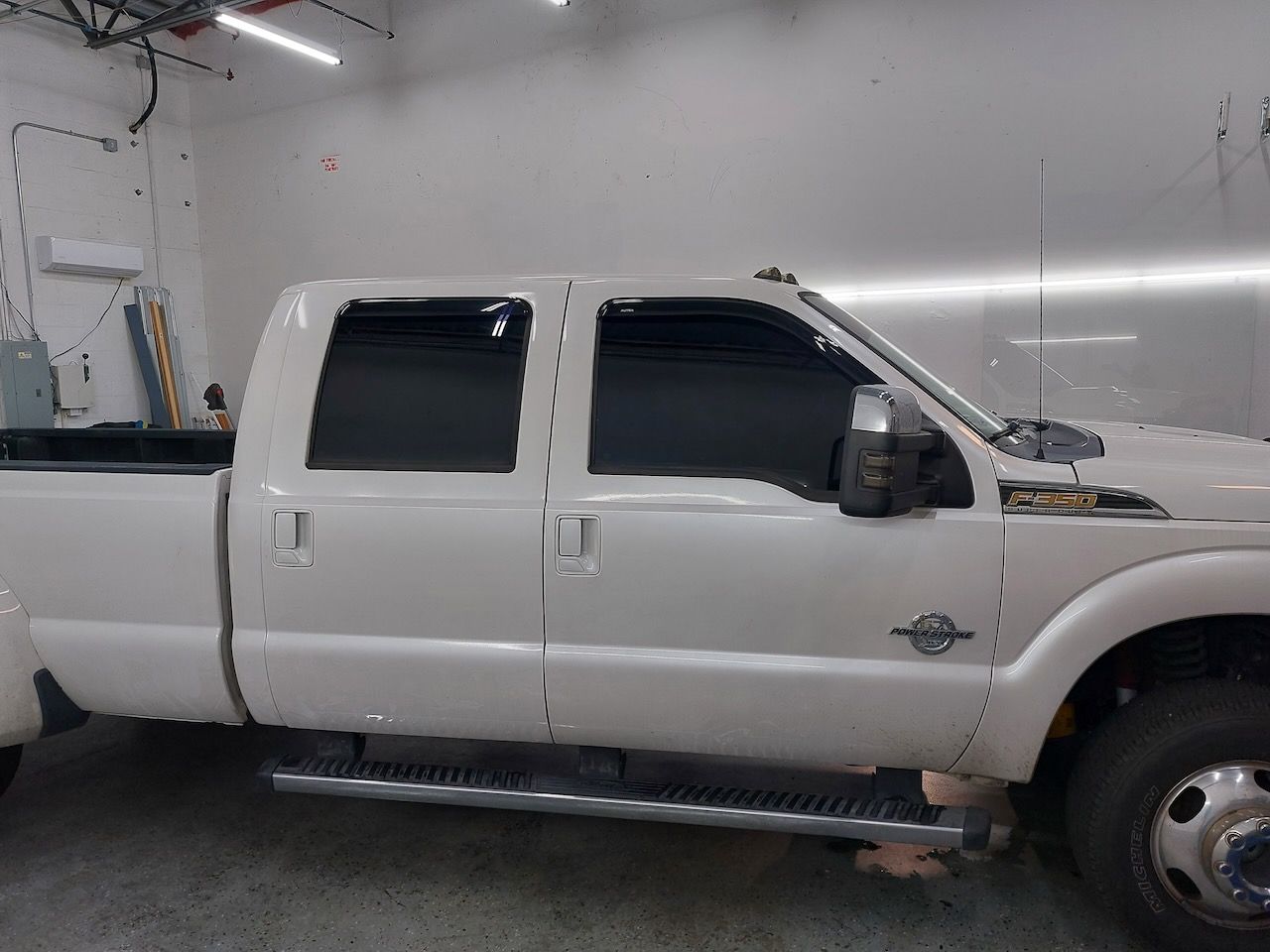 A white pickup truck is parked in a garage.