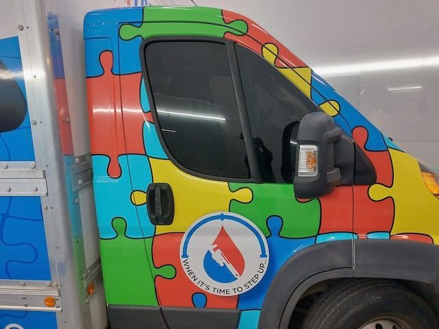 A colorful van with puzzle pieces painted on it