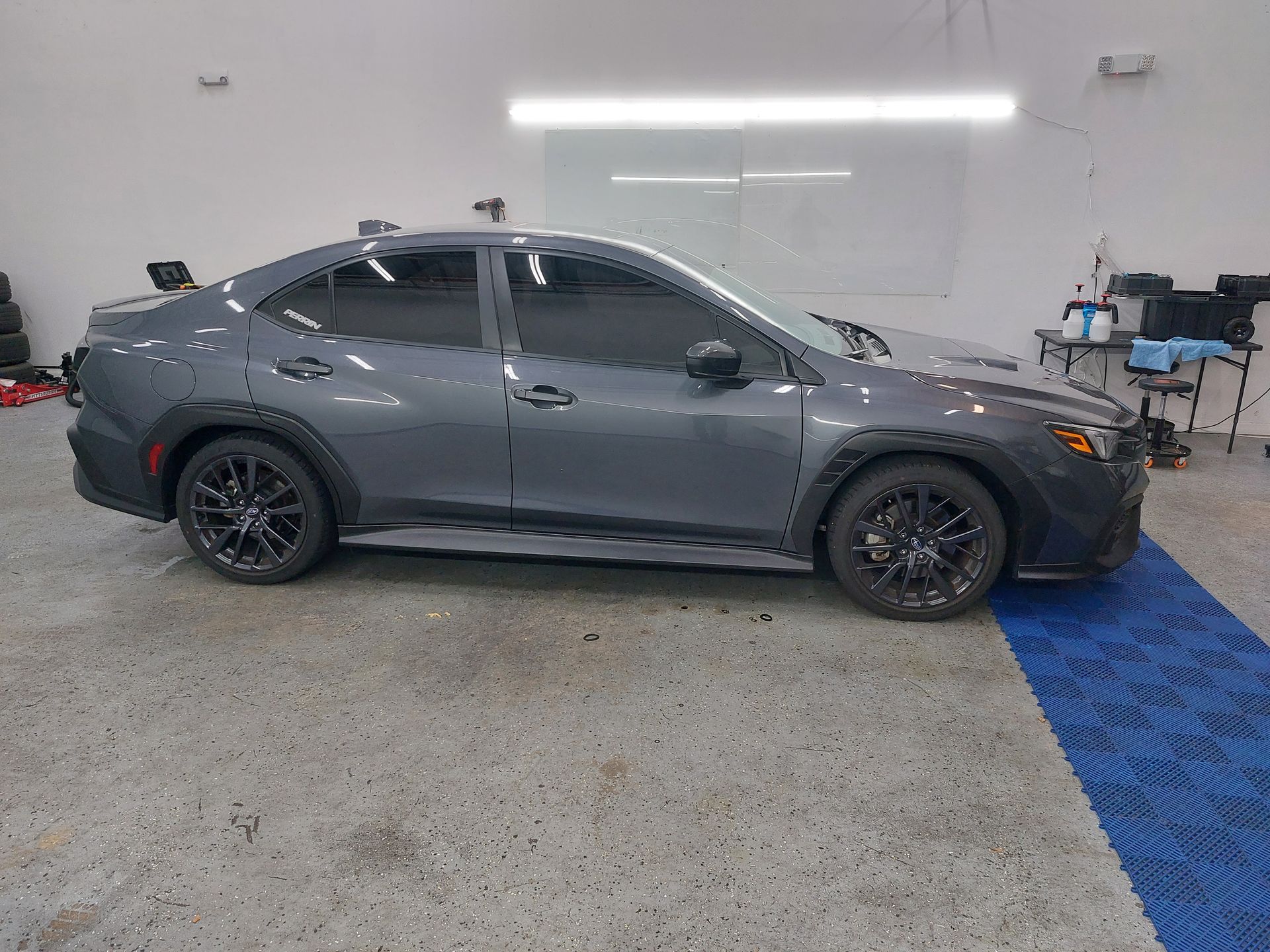 A gray car is parked in a garage.