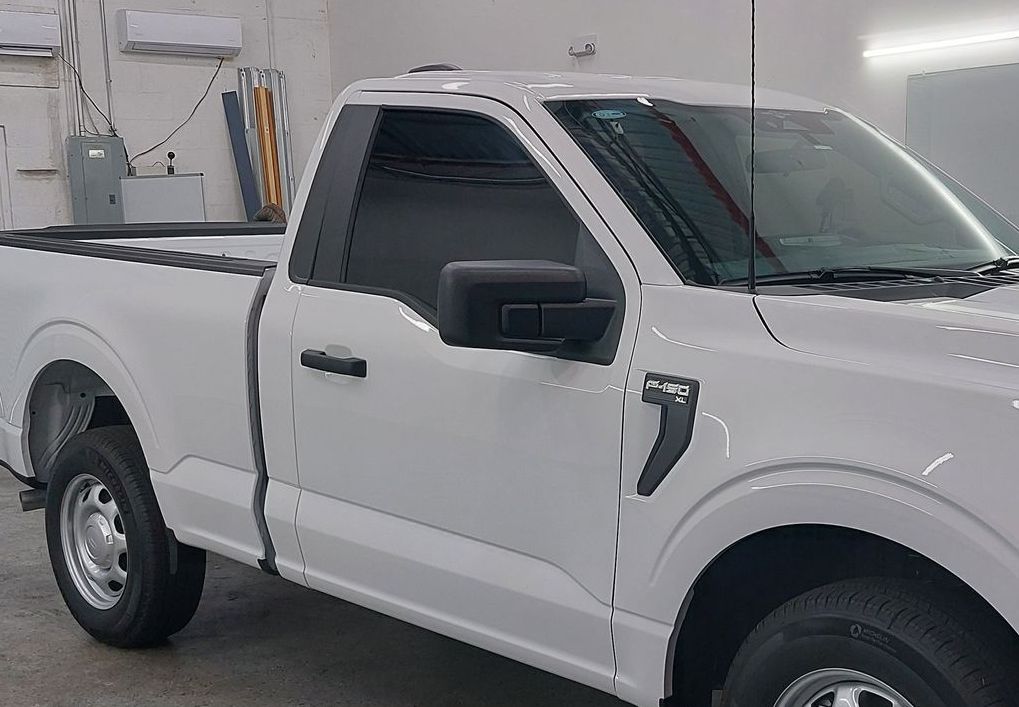 A white pickup truck is parked in a garage.