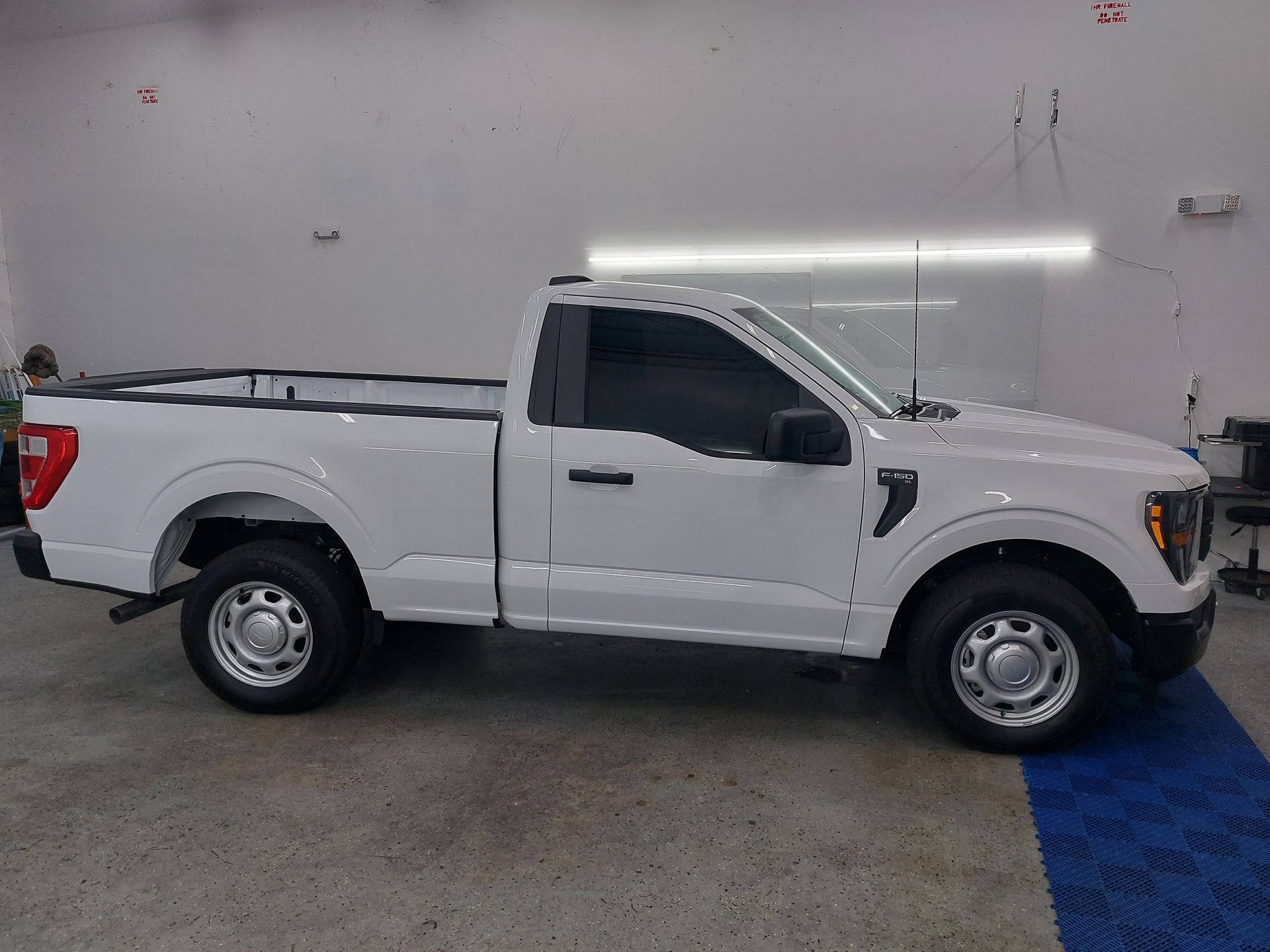 A white pickup truck is parked in a garage.