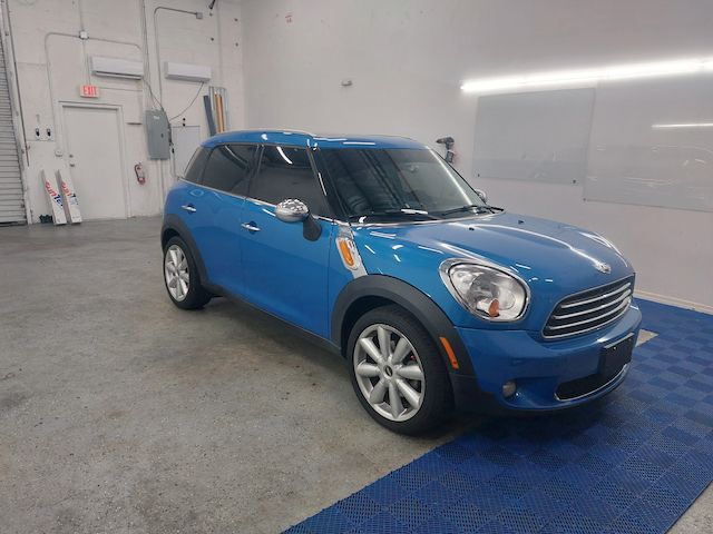 A blue mini cooper is parked in a garage.