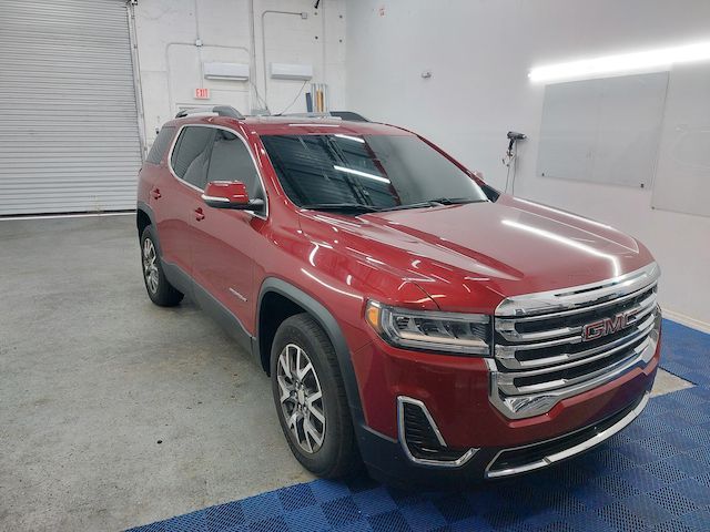 A red gmc acadia is parked in a garage.