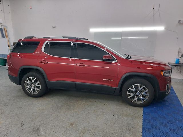 A red gmc acadia is parked in a garage.