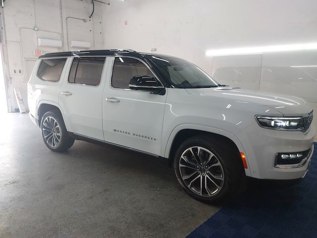 A white jeep wrangler is parked in a garage.