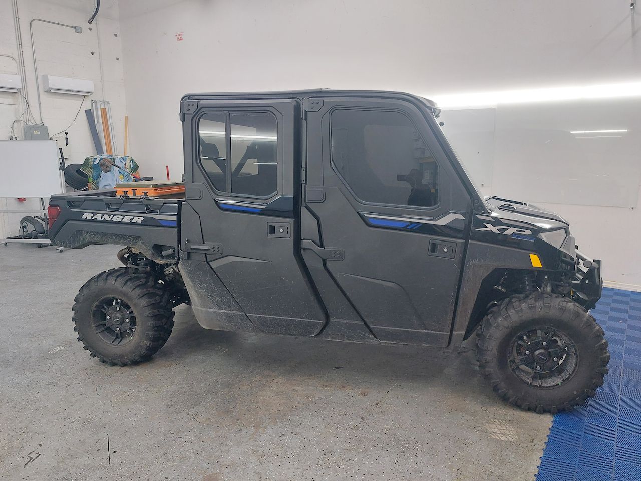A black utility vehicle is parked in a garage.