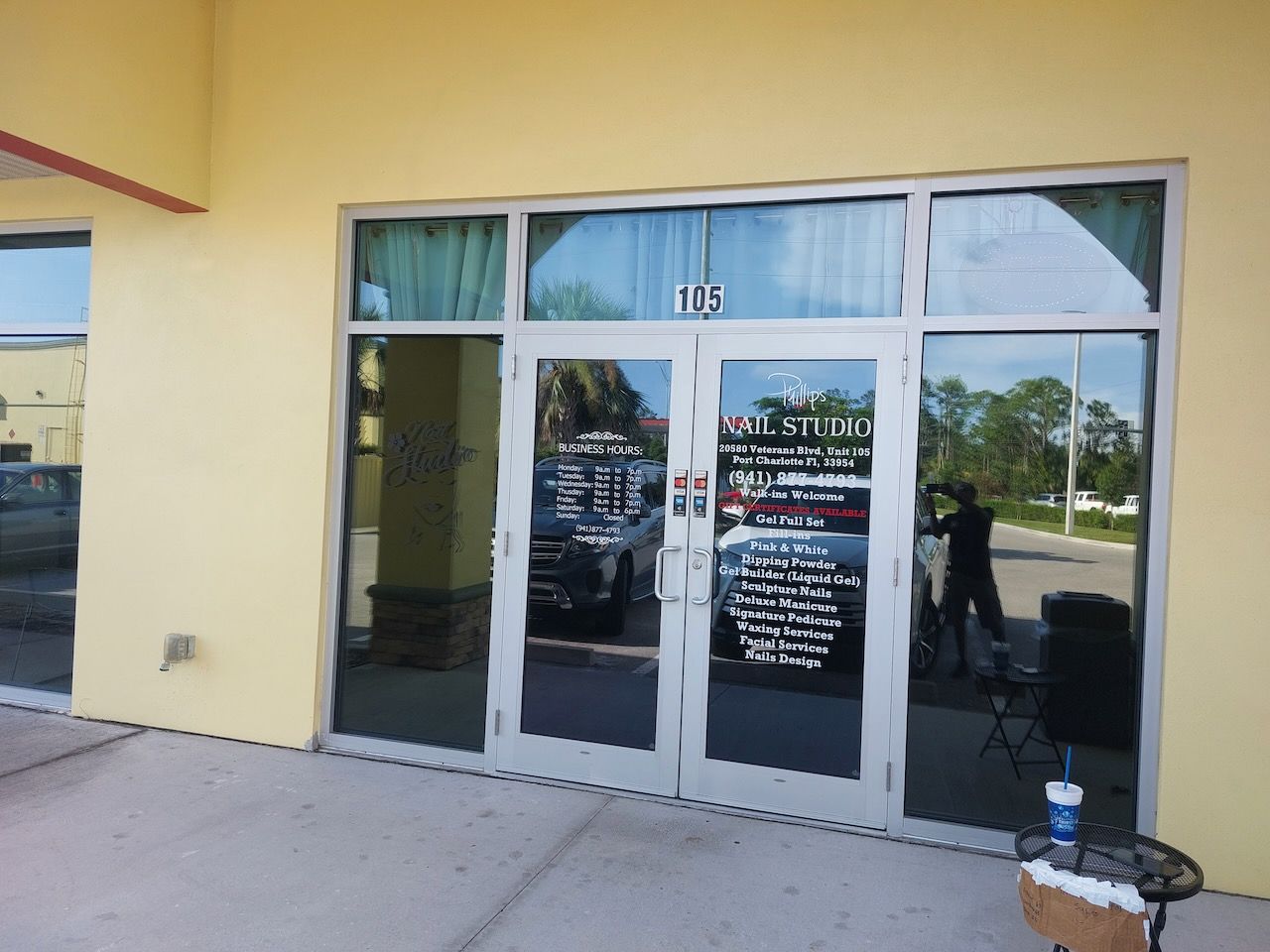 A yellow building with a reflection of cars in the windows